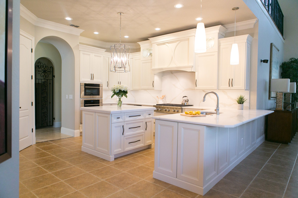Example of a mid-sized transitional u-shaped open concept kitchen design in Orlando with an undermount sink, recessed-panel cabinets, white cabinets, quartzite countertops, white backsplash, stone slab backsplash, stainless steel appliances and a peninsula