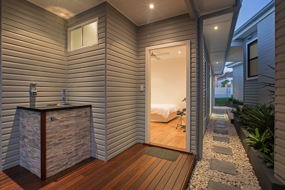 Inspiration for a mid-sized contemporary one-storey blue house exterior in Sydney with wood siding, a hip roof and a metal roof.