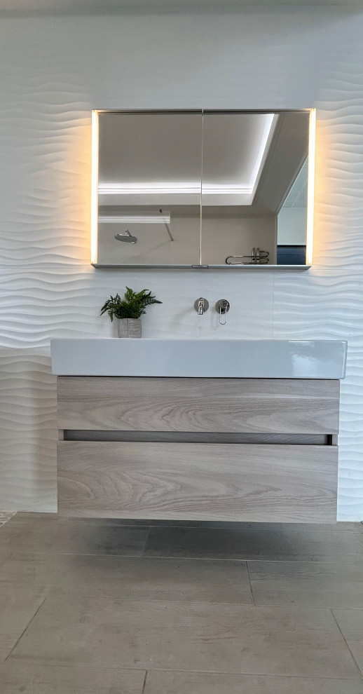This is an example of a large scandinavian ensuite wet room bathroom in Berkshire with flat-panel cabinets, light wood cabinets, white tiles, porcelain tiles, white walls, porcelain flooring, a trough sink, beige floors, an open shower, an enclosed toilet, a single sink, a floating vanity unit and a coffered ceiling.