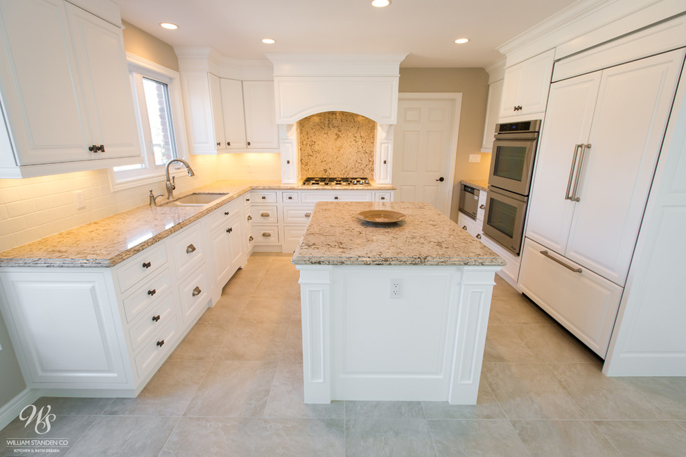 Example of a mid-sized transitional u-shaped porcelain tile eat-in kitchen design in Toronto with an undermount sink, raised-panel cabinets, white cabinets, quartzite countertops, beige backsplash, stone slab backsplash, stainless steel appliances and an island