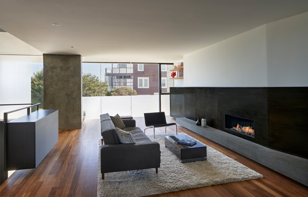 Design ideas for a modern loft-style living room in San Francisco with white walls, medium hardwood floors, a ribbon fireplace, a metal fireplace surround, a built-in media wall and brown floor.
