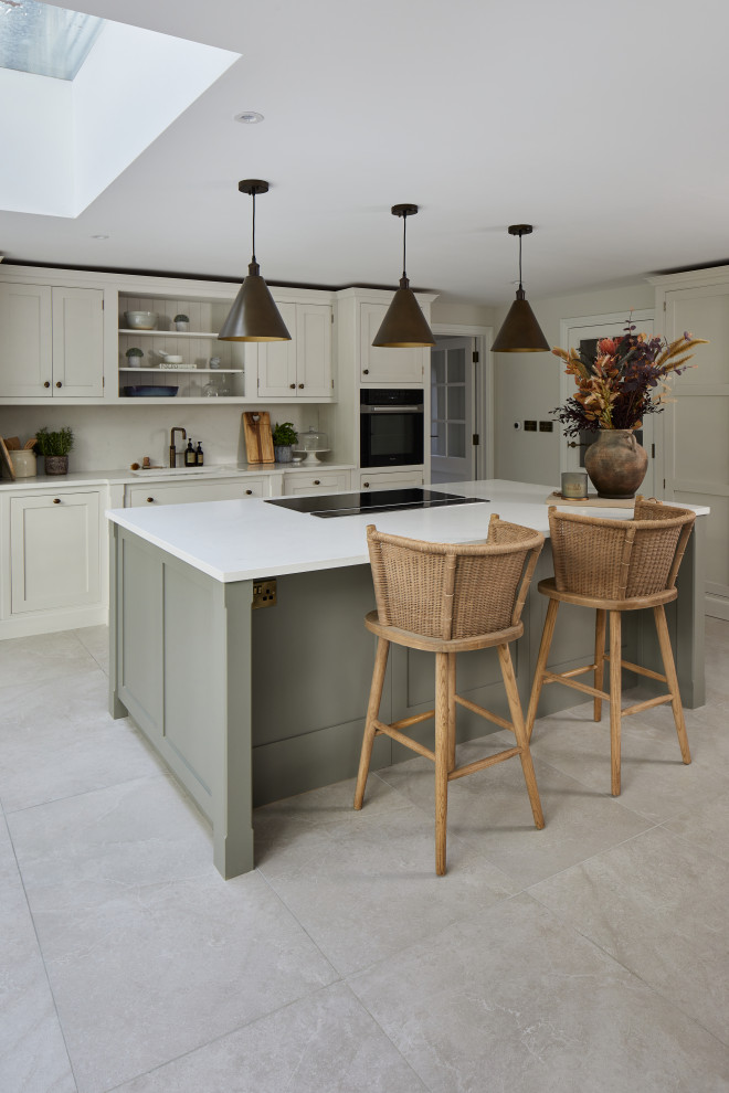 Large contemporary single-wall open plan kitchen in Wiltshire with a built-in sink, shaker cabinets, composite countertops, grey splashback, stainless steel appliances, porcelain flooring, an island, grey floors and white worktops.