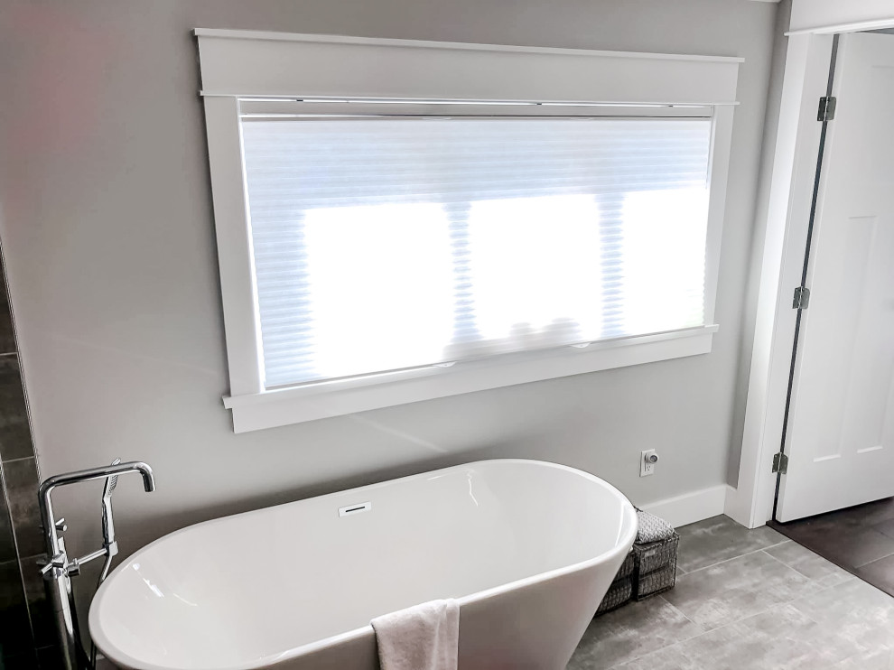 Large transitional master bathroom in Other with a freestanding tub, gray tile, grey walls, grey floor and ceramic floors.