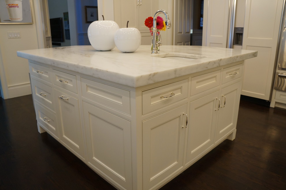Example of a mid-sized transitional u-shaped dark wood floor and brown floor eat-in kitchen design in Boston with an undermount sink, recessed-panel cabinets, white cabinets, marble countertops, white backsplash, stone slab backsplash, stainless steel appliances, two islands and white countertops