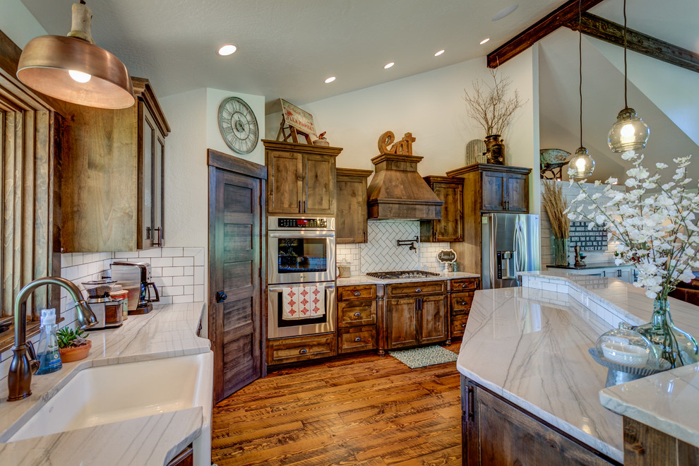 Mid-sized mountain style u-shaped medium tone wood floor kitchen photo in Seattle with an undermount sink, shaker cabinets, medium tone wood cabinets, quartzite countertops, white backsplash, stone tile backsplash, stainless steel appliances and an island
