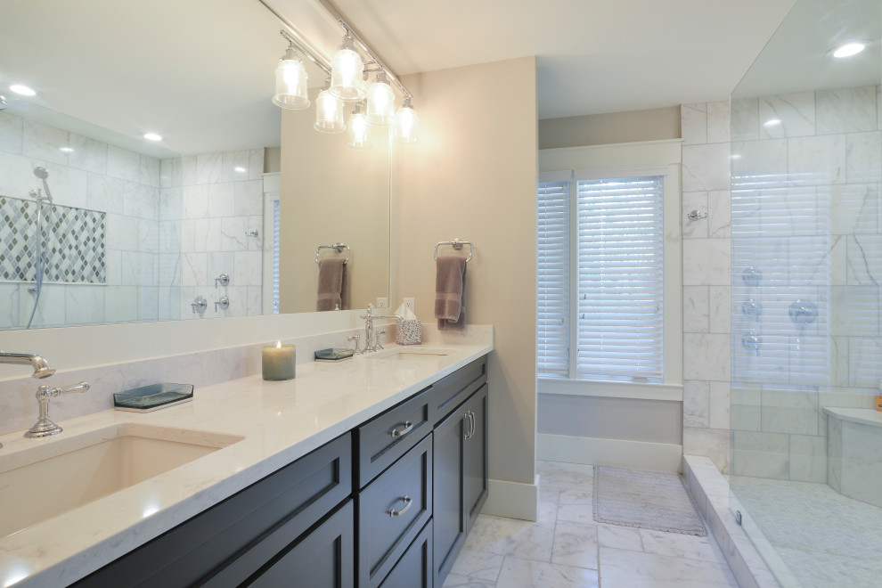 Example of a mid-sized transitional master gray tile and stone tile marble floor and gray floor doorless shower design with shaker cabinets, gray cabinets, a two-piece toilet, beige walls, an undermount sink, quartz countertops and white countertops
