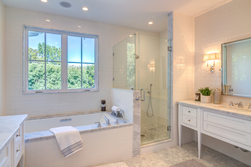 This is an example of a mid-sized transitional master bathroom in Los Angeles with shaker cabinets, white cabinets, an undermount tub, an alcove shower, a one-piece toilet, gray tile, white tile, porcelain tile, white walls, mosaic tile floors, an undermount sink and marble benchtops.