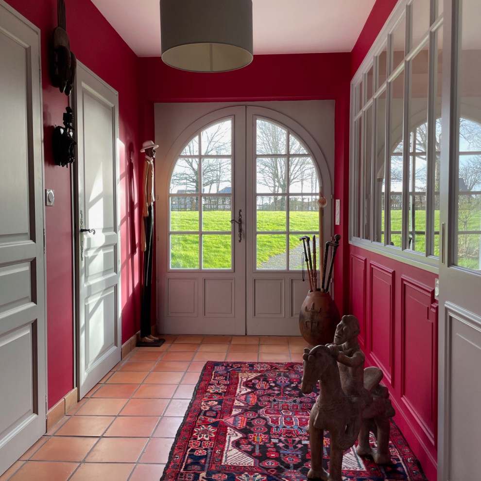 Esempio di un grande ingresso country con pareti rosse, pavimento in terracotta, una porta a due ante e una porta grigia