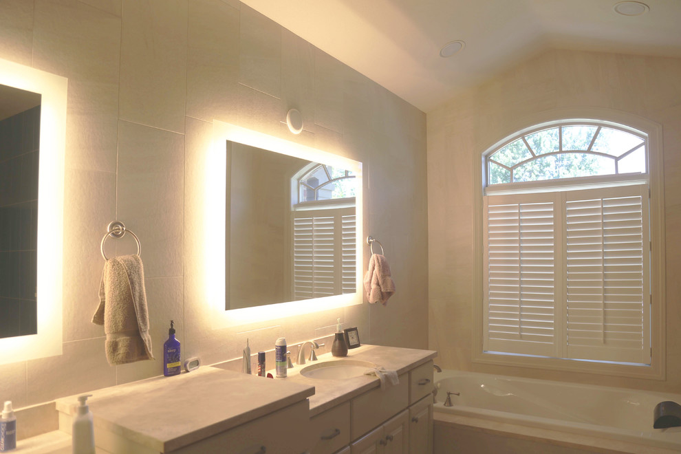 Inspiration for a mid-sized transitional master white tile and porcelain tile porcelain tile drop-in bathtub remodel with raised-panel cabinets, white cabinets, a two-piece toilet, white walls, an undermount sink and granite countertops