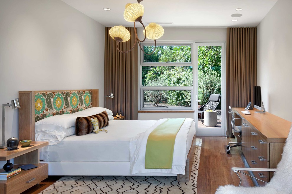 This is an example of a contemporary bedroom in San Francisco with grey walls, medium hardwood floors and brown floor.