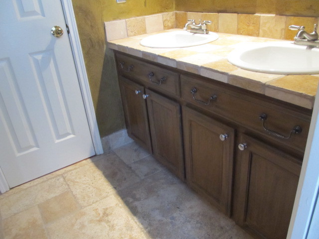 This is an example of a traditional bathroom in Austin with a drop-in sink, limestone benchtops, brown tile, stone tile, beige walls and travertine floors.