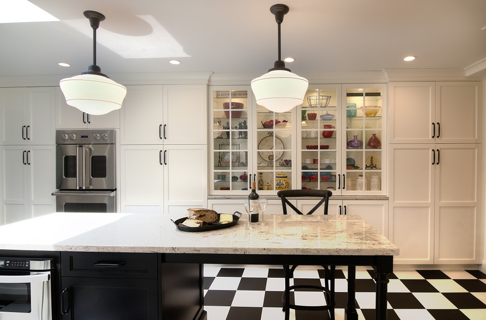 Enclosed kitchen - transitional u-shaped multicolored floor enclosed kitchen idea with a farmhouse sink, glass-front cabinets, white cabinets, granite countertops, white backsplash, subway tile backsplash, stainless steel appliances, an island and beige countertops