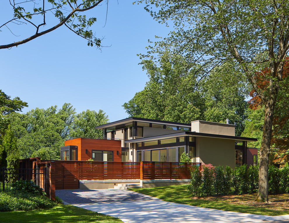 Mid-sized contemporary two-storey stucco grey house exterior in DC Metro with a flat roof and a mixed roof.
