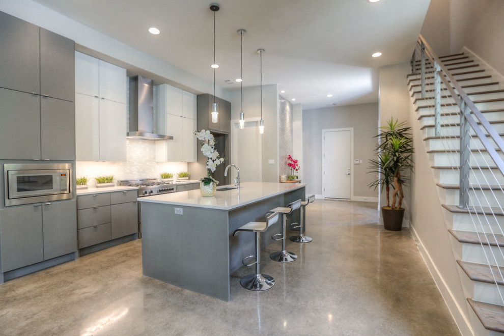 Transitional single-wall eat-in kitchen in Houston with an undermount sink, flat-panel cabinets, grey cabinets, quartz benchtops, blue splashback, stainless steel appliances, concrete floors, with island and grey floor.