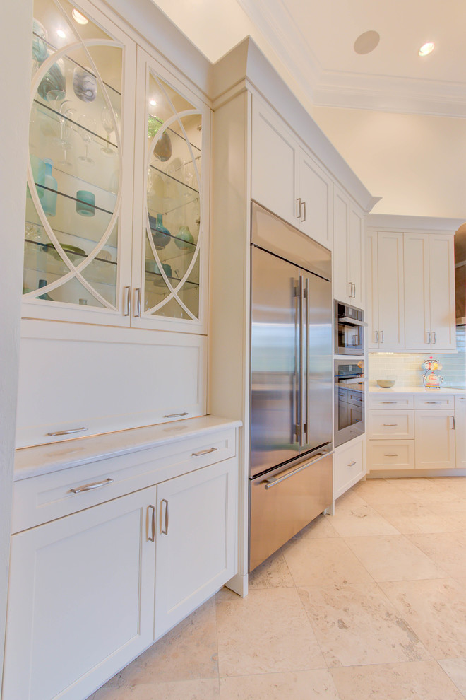 Example of a large transitional single-wall enclosed kitchen design with an undermount sink, flat-panel cabinets, white cabinets, quartz countertops, blue backsplash, stone tile backsplash, stainless steel appliances and an island