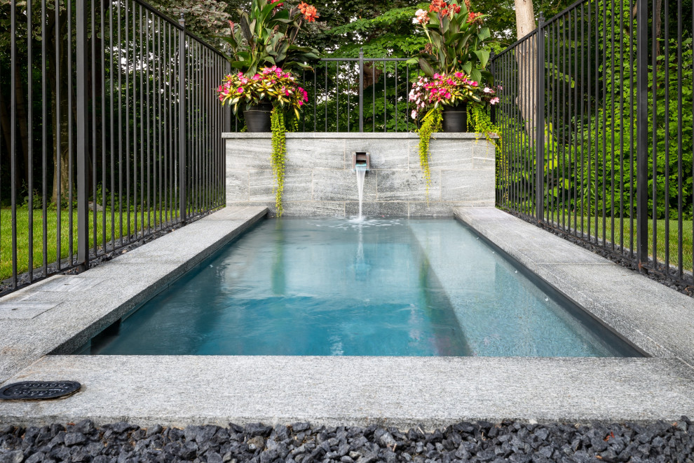 Inspiration for a small transitional backyard rectangular pool in Toronto with a hot tub and natural stone pavers.