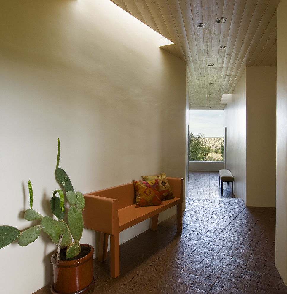 Photo of a mid-sized hallway in Albuquerque with brick floors.