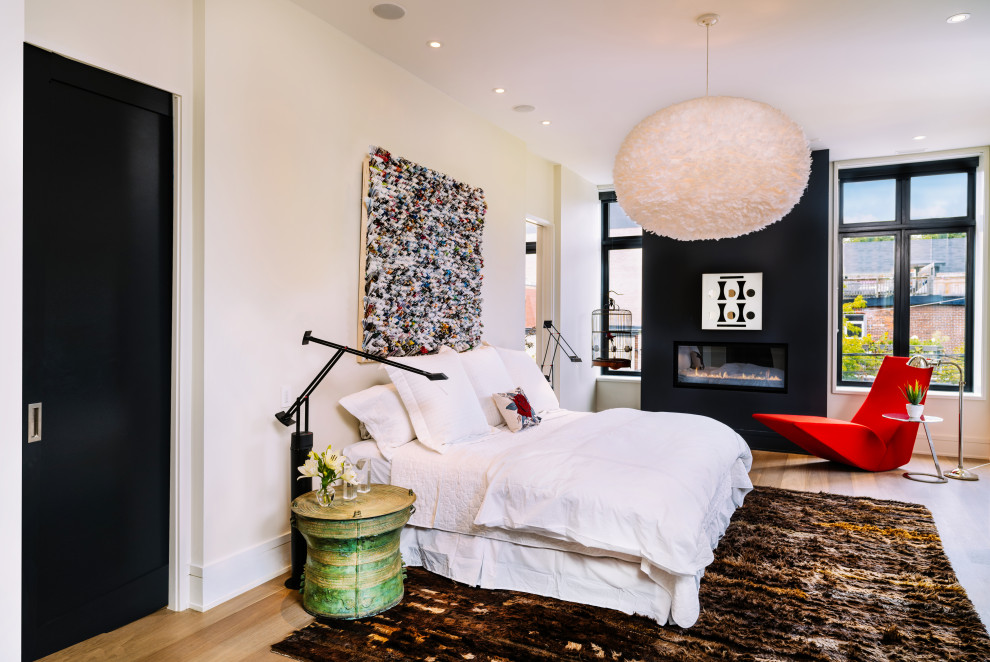 Идея дизайна: хозяйская спальня среднего размера в стиле фьюжн с черными стенами, полом из бамбука, горизонтальным камином и фасадом камина из штукатурки
