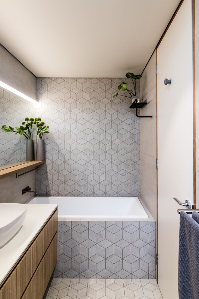 Modern bathroom in Perth with medium wood cabinets, a drop-in tub, grey walls, cement tiles, a vessel sink, grey floor, white benchtops, an open shower, ceramic tile, an open shower and a single vanity.