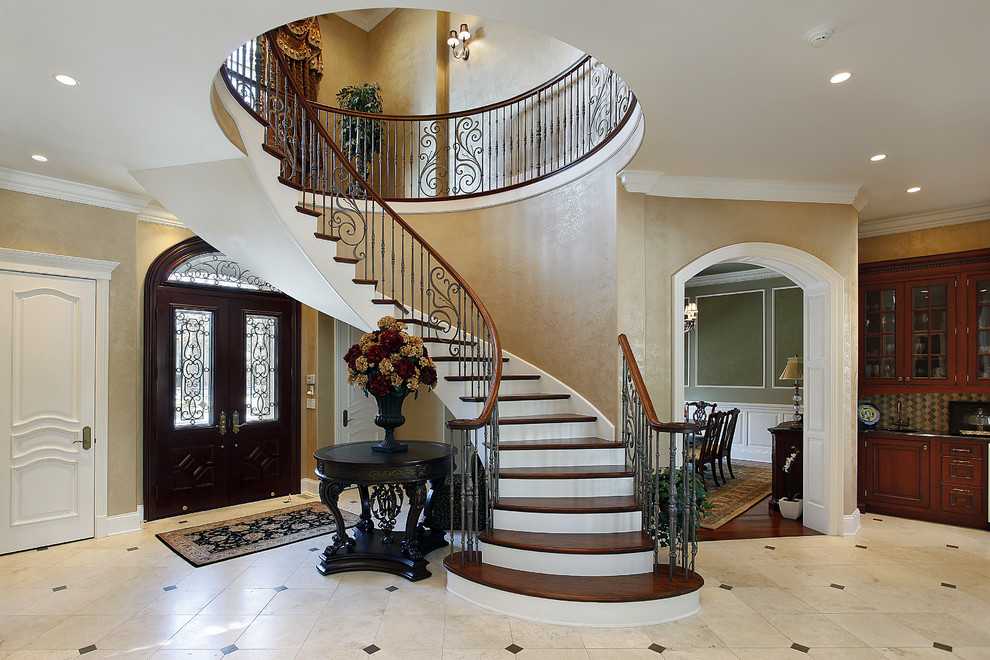 This is an example of a large mediterranean wood spiral staircase in Other with painted wood risers and metal railing.