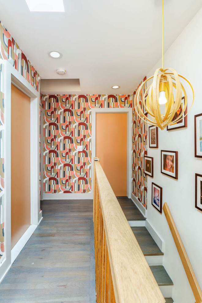 Small midcentury hallway in New York with multi-coloured walls, medium hardwood floors, grey floor and wallpaper.