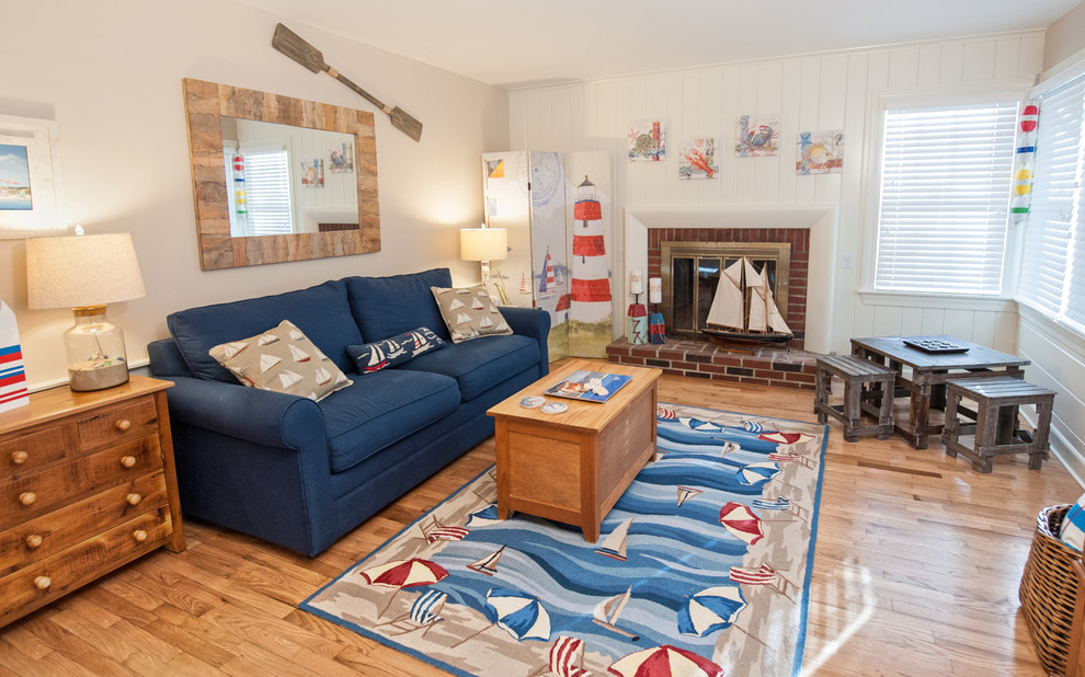 Inspiration for a mid-sized beach style loft-style family room in Boston with a game room, white walls, medium hardwood floors, a standard fireplace, a brick fireplace surround and no tv.