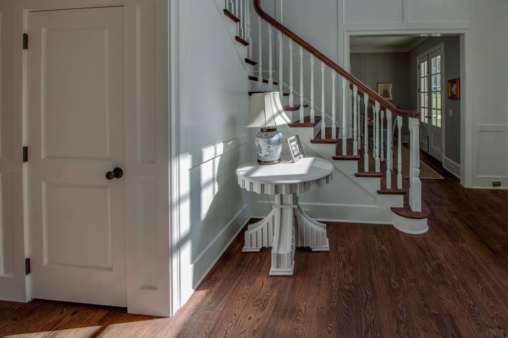 Photo of a mid-sized traditional foyer in Charlotte with white walls and dark hardwood floors.