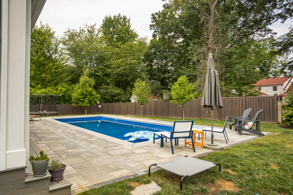 Large transitional backyard concrete paver and rectangular lap pool photo in Cincinnati