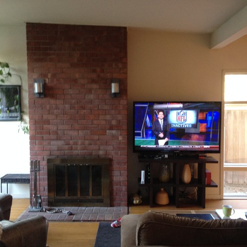 I am trying to create a television/fireplace combination as a focal point in a combined dining and living area.  The house is an "eichler-style" house with tall windows throughout.  My husband wants to leave the existing brick