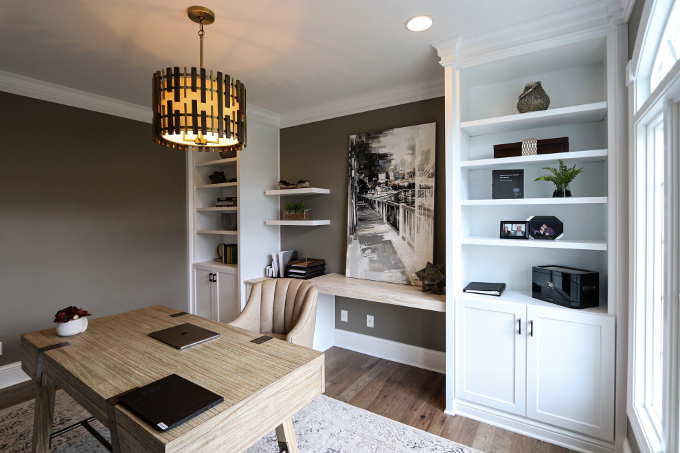Idee per un ufficio chic di medie dimensioni con pareti beige, pavimento in legno massello medio, scrivania autoportante e pavimento marrone