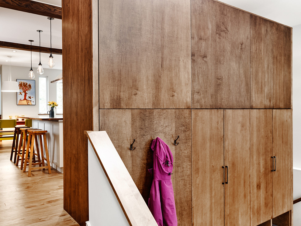 Example of a mid-sized transitional medium tone wood floor mudroom design with white walls