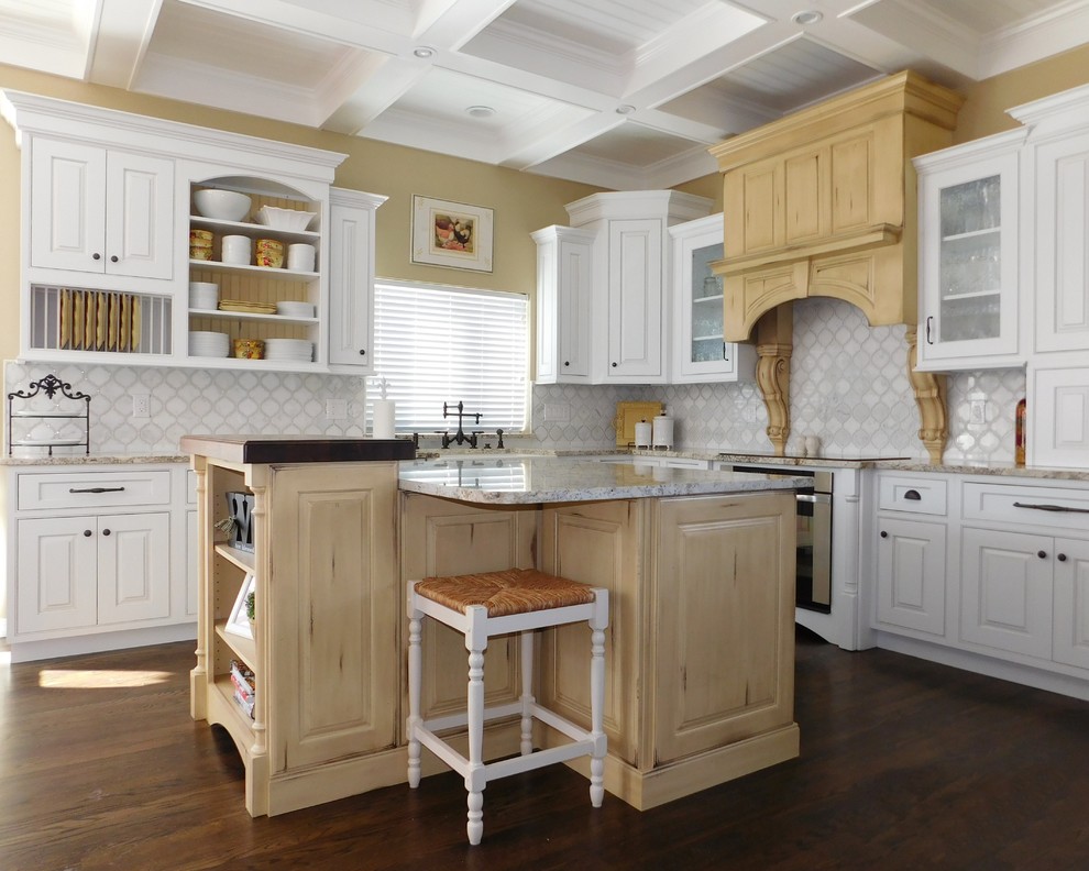 Large romantic l-shaped kitchen/diner in Denver with a belfast sink, raised-panel cabinets, white cabinets, granite worktops, white splashback, marble splashback, stainless steel appliances, dark hardwood flooring, an island, brown floors, grey worktops and a coffered ceiling.