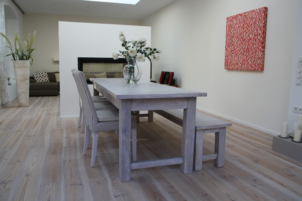 This is an example of a mid-sized contemporary open plan dining in Other with beige walls and light hardwood floors.