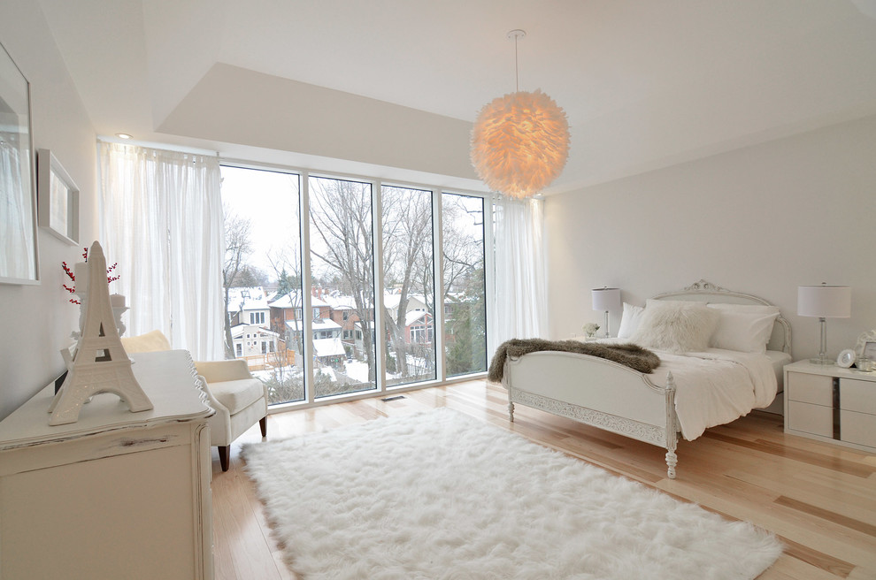 Mid-sized contemporary master bedroom in Toronto with white walls, light hardwood floors, no fireplace and brown floor.