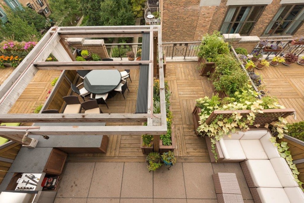 Small transitional rooftop full sun garden in Chicago with a container garden and decking for summer.