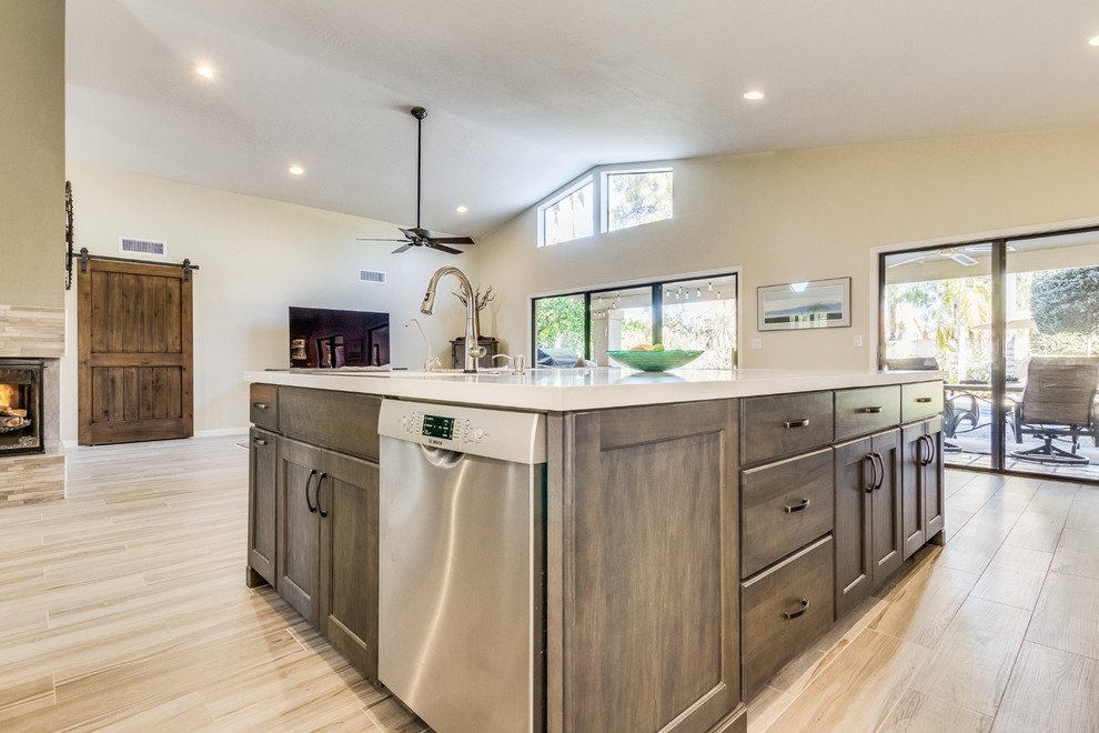 This is an example of a mid-sized contemporary eat-in kitchen in Phoenix with an undermount sink, shaker cabinets, medium wood cabinets, quartz benchtops, white splashback, subway tile splashback, stainless steel appliances, porcelain floors, with island, beige floor and white benchtop.