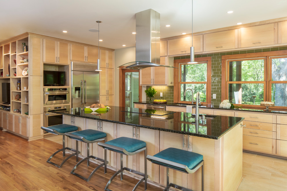 Inspiration for a mid-sized contemporary kitchen in Austin with flat-panel cabinets, light wood cabinets, granite benchtops, green splashback, glass tile splashback, stainless steel appliances and with island.