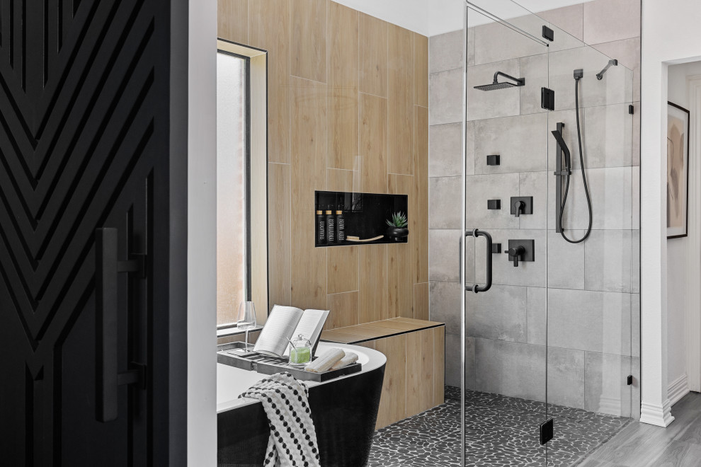 Example of a trendy beige tile and gray tile pebble tile floor and gray floor freestanding bathtub design in Dallas with white walls, a hinged shower door and a niche