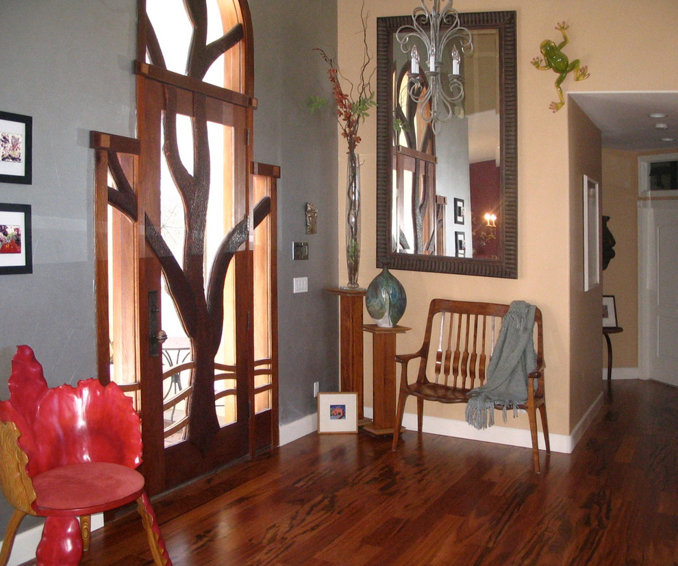Example of a large eclectic dark wood floor foyer design with multicolored walls and a glass front door
