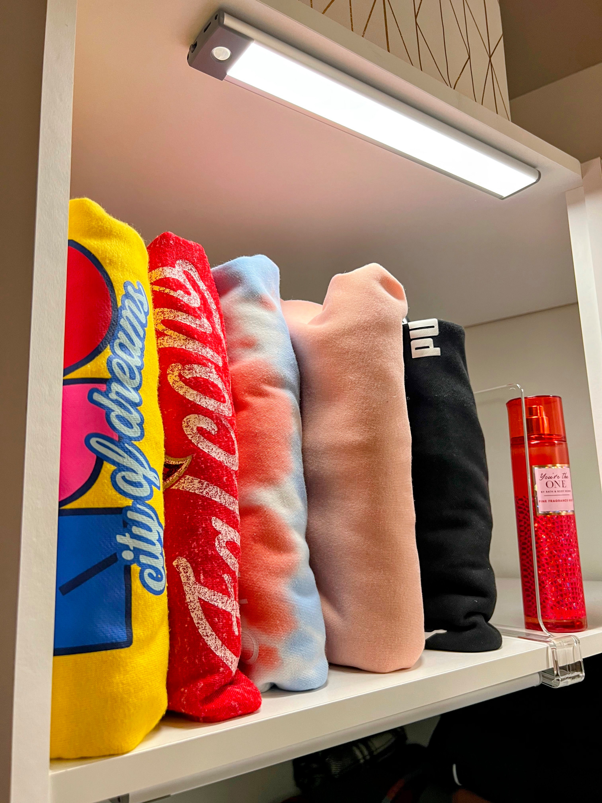 An image of an organized custom closet compartment with standing tshirts completed by Calming Home by Venus