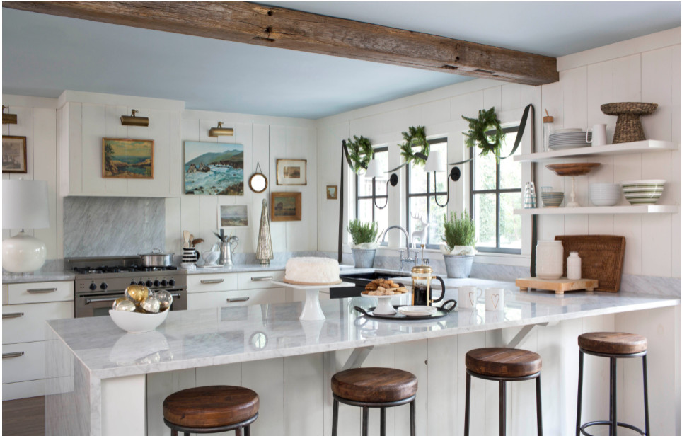 Picture-Perfect Christmas Kitchen. bright kitchen gets pops of green from wreaths above the windows, a velvet ribbon swag, and potted rosemary. Picture lights illuminate the art collection.