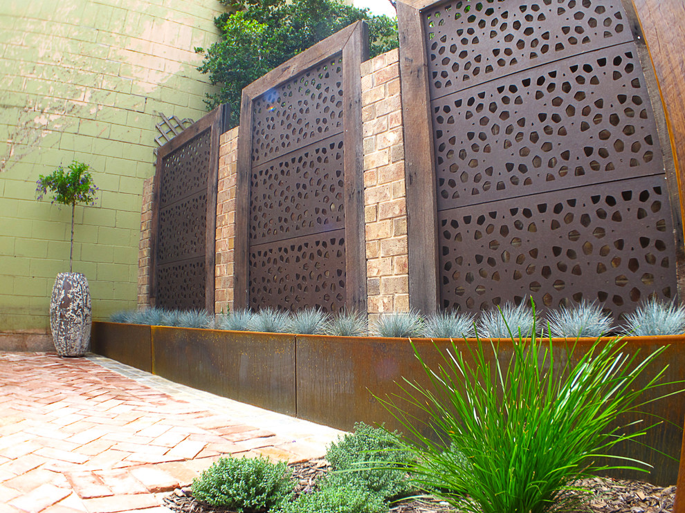 Small and australian native eclectic backyard formal garden in Adelaide with brick pavers.