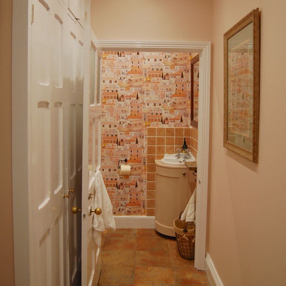 Inspiration for a small rustic cloakroom in West Midlands with recessed-panel cabinets, a one-piece toilet, pink tiles, ceramic tiles, pink walls, ceramic flooring, a wall-mounted sink, wooden worktops, orange floors, pink worktops, a feature wall and a built in vanity unit.