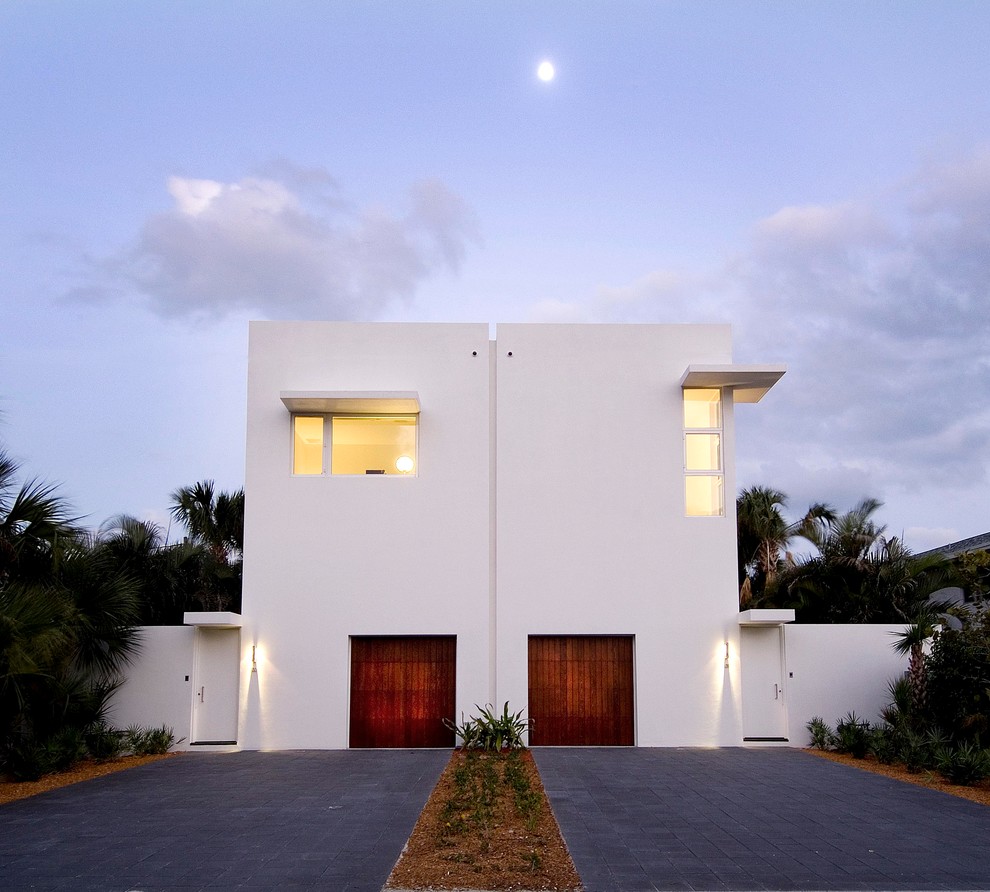 This is an example of a modern two-storey stucco duplex exterior in Miami with a flat roof.
