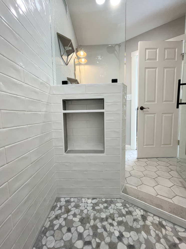 This is an example of a small country 3/4 bathroom in Other with raised-panel cabinets, brown cabinets, a corner shower, a two-piece toilet, white tile, subway tile, grey walls, ceramic floors, a vessel sink, quartzite benchtops, grey floor, a hinged shower door, black benchtops, a niche, a single vanity and a freestanding vanity.