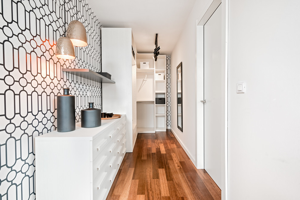 Photo of a contemporary gender-neutral walk-in wardrobe in Malaga with open cabinets, white cabinets and laminate floors.