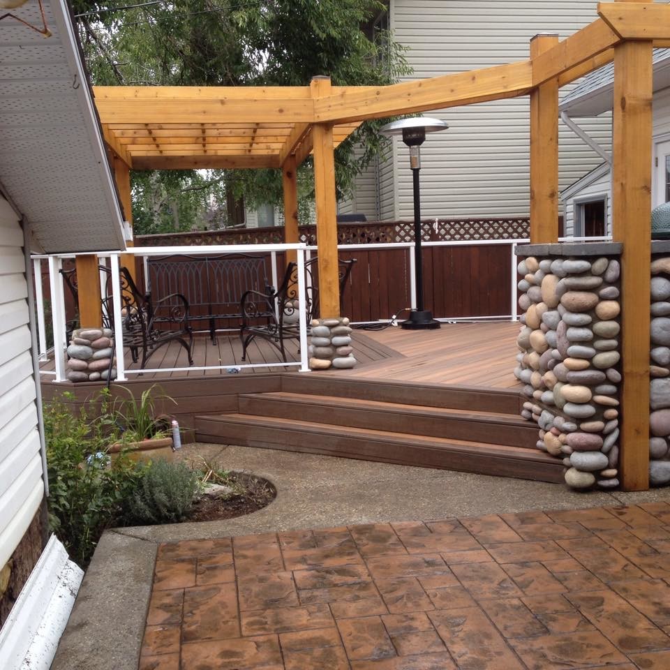 Inspiration for a large eclectic backyard outdoor kitchen deck remodel in Calgary with a pergola