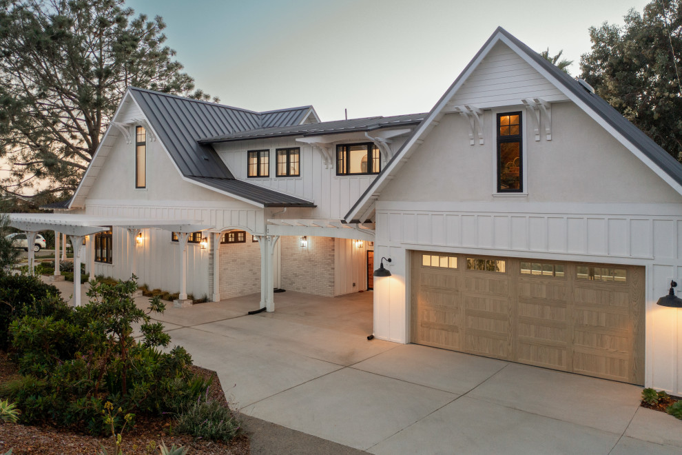 Idée de décoration pour une façade de maison blanche champêtre en planches et couvre-joints de taille moyenne et à un étage avec un revêtement mixte, un toit à deux pans, un toit en métal et un toit gris.