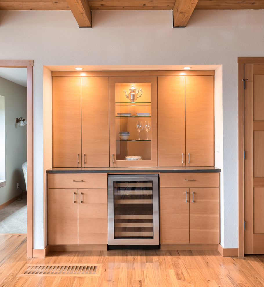 Photo of a mid-sized contemporary single-wall home bar in Portland with flat-panel cabinets, light wood cabinets, quartz benchtops and medium hardwood floors.