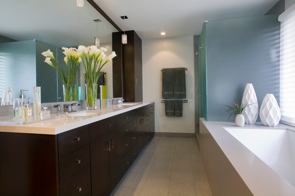 This is an example of a large contemporary master bathroom in Los Angeles with an undermount sink, flat-panel cabinets, dark wood cabinets, an undermount tub, a corner shower, gray tile, porcelain tile, grey walls and porcelain floors.